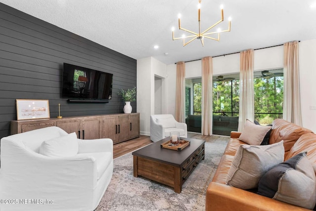 126 Seahill Dr, Saint Augustine, FL 32092 - living area with light wood finished floors, a textured ceiling, wood walls, and an inviting chandelier