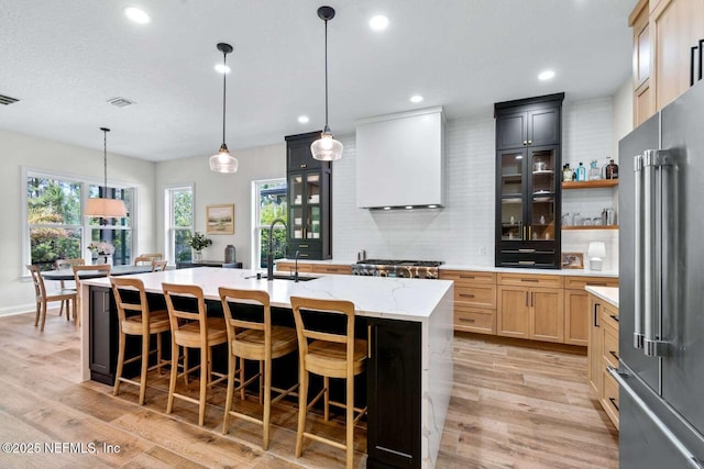 126 Seahill Dr, Saint Augustine, FL 32092 - kitchen featuring an island with sink, high quality fridge, backsplash, a sink, and visible vents