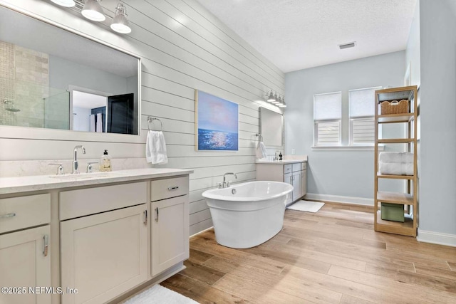 126 Seahill Dr, Saint Augustine, FL 32092 - full bathroom featuring a shower stall, wood finished floors, a sink, and a textured ceiling