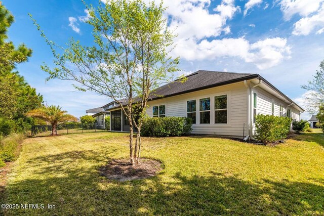126 Seahill Dr, Saint Augustine, FL 32092 - rear view of house featuring a sunroom, fence, and a lawn