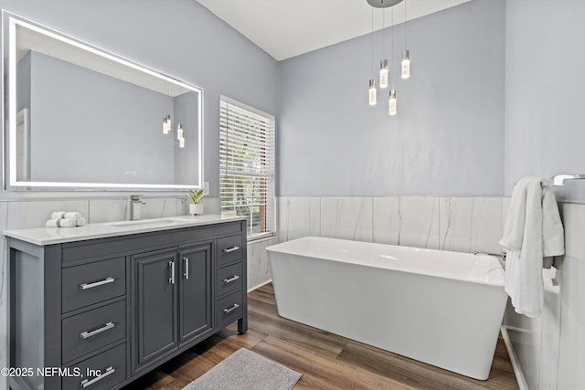 1053 Anchor Rd, Saint Johns, FL 32259 - full bathroom with vanity, tile walls, a wainscoted wall, a freestanding bath, and wood finished floors