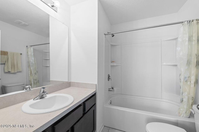 full bath with vanity, a textured ceiling, toilet, and shower / tub combo