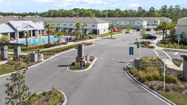 view of street with sidewalks, a residential view, a gated entry, and curbs