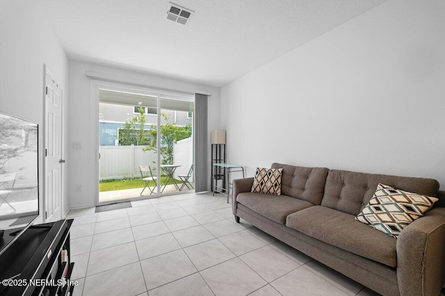 living area with visible vents and light tile patterned floors