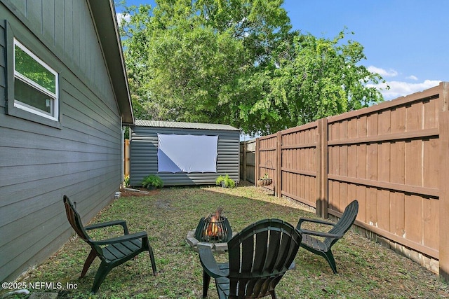 1202 Wolfe St, Jacksonville, FL 32205 - fenced backyard with an outdoor fire pit, a storage unit, and an outbuilding