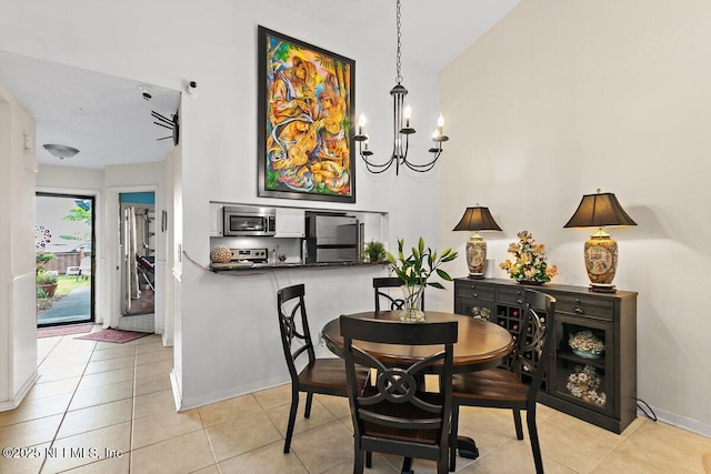 1202 Wolfe St, Jacksonville, FL 32205 - dining area featuring a chandelier, light tile patterned floors, a high ceiling, and baseboards