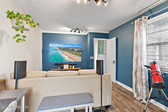 1202 Wolfe St, Jacksonville, FL 32205 - living room with a textured ceiling, rail lighting, wood finished floors, and baseboards