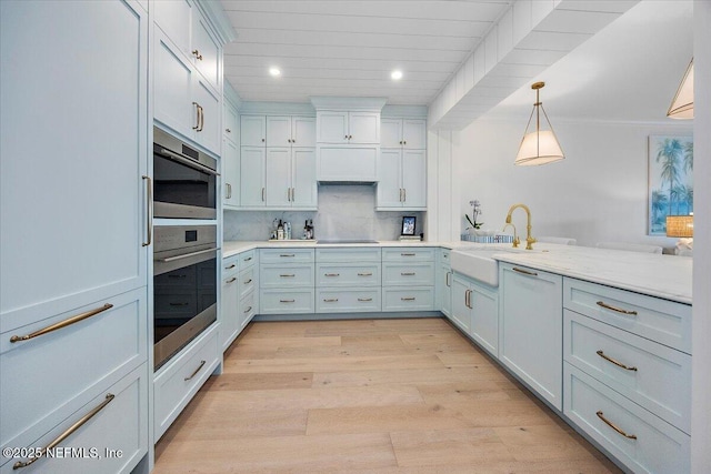 701 Beach Ave Unit 204, Atlantic Beach, FL 32233 - kitchen with a sink, light countertops, recessed lighting, light wood-type flooring, and backsplash