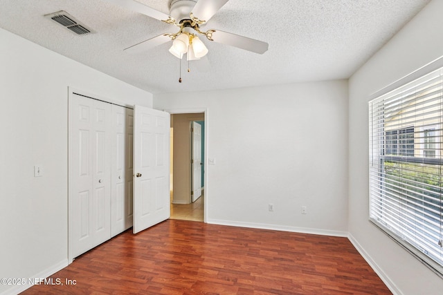 104 Seaside Cir, Ponte Vedra Beach, FL 32082 - unfurnished bedroom featuring wood finished floors, a textured ceiling, baseboards, a closet, and ceiling fan