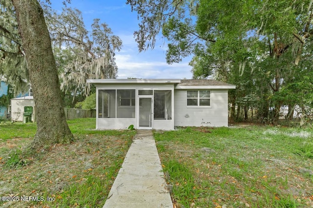 161 W 65th St, Jacksonville, FL 32208 - bungalow featuring a front yard, a sunroom, and fence