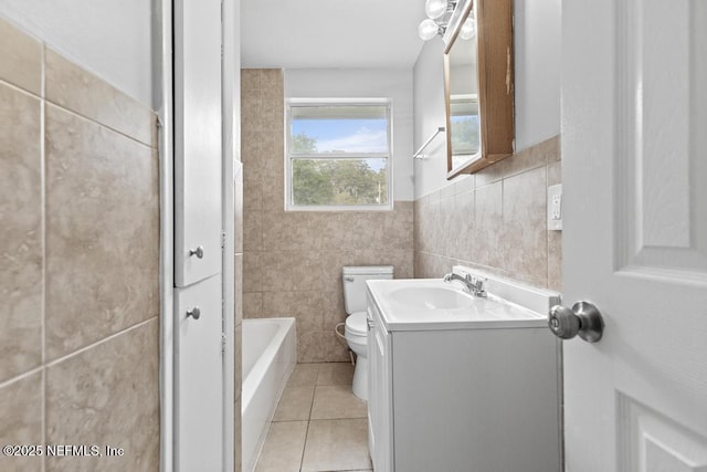 161 W 65th St, Jacksonville, FL 32208 - bathroom featuring tile patterned floors, toilet, a tub to relax in, vanity, and tile walls