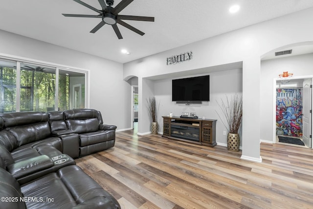 141 Casa Sevilla Ave, Saint Augustine, FL 32092 - living room featuring a ceiling fan, visible vents, a healthy amount of sunlight, arched walkways, and light wood finished floors