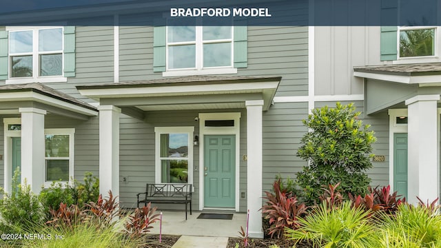 doorway to property with board and batten siding and a porch
