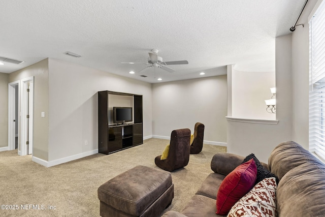 living room featuring carpet flooring, a textured ceiling, visible vents, and ceiling fan