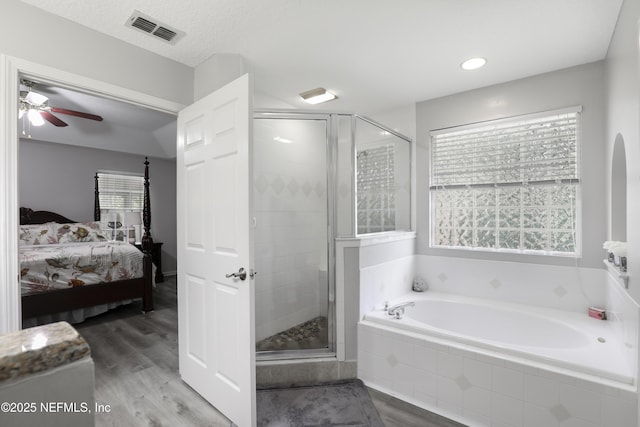 96086 Sea Winds Dr, Fernandina Beach, FL 32034 - bathroom featuring connected bathroom, a bath, a shower stall, and wood finished floors