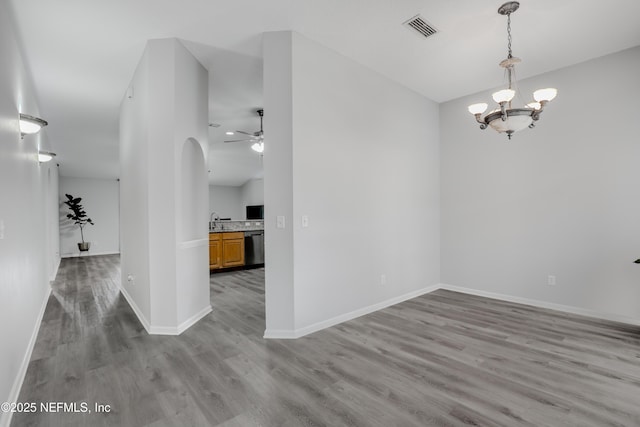 96086 Sea Winds Dr, Fernandina Beach, FL 32034 - unfurnished dining area featuring light wood finished floors, a ceiling fan, a chandelier, arched walkways, and baseboards