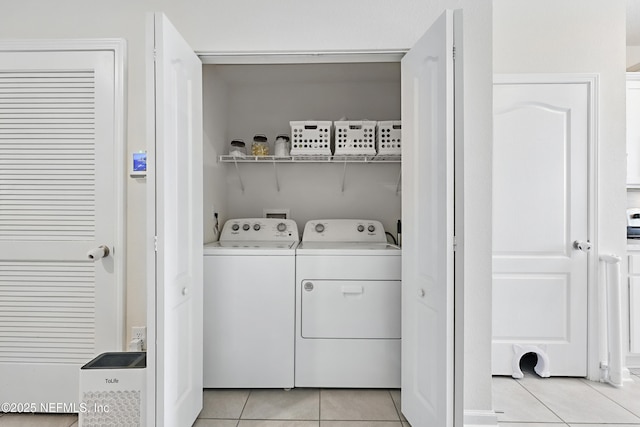 clothes washing area featuring washer and dryer, laundry area, and light tile patterned floors