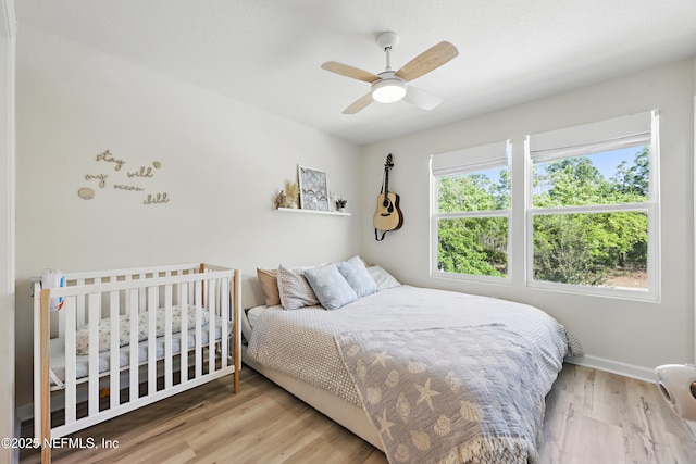 bedroom featuring baseboards, wood finished floors, and ceiling fan