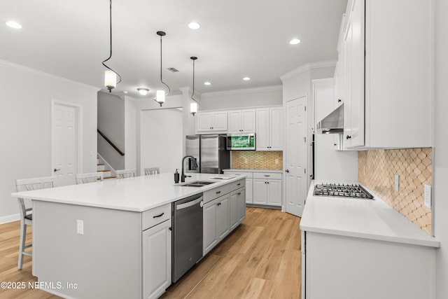 113 Footbridge Rd, Saint Johns, FL 32259 - kitchen with white cabinetry, a breakfast bar area, a sink, light wood-style flooring, and appliances with stainless steel finishes