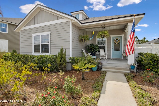 view of front of property featuring board and batten siding, a porch, and fence