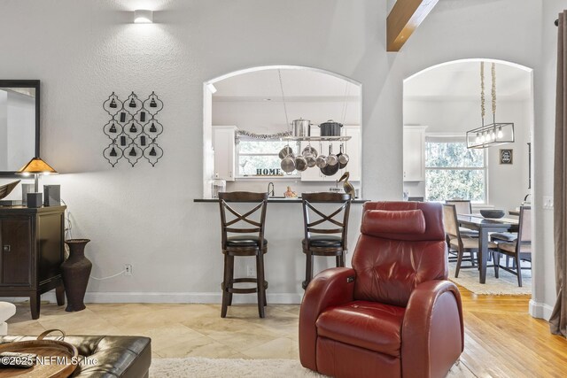 4 Pamela Pkwy, Palm Coast, FL 32137 - living area with baseboards, arched walkways, and an inviting chandelier