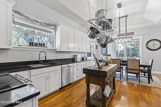 4 Pamela Pkwy, Palm Coast, FL 32137 - kitchen with hardwood / wood-style flooring, a textured ceiling, white cabinetry, and dishwasher