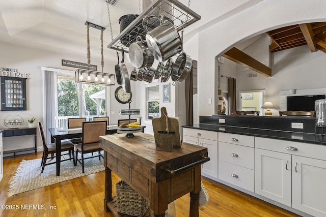 4 Pamela Pkwy, Palm Coast, FL 32137 - kitchen with white cabinetry, dark countertops, arched walkways, visible vents, and light wood-style flooring