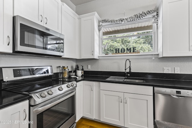 4 Pamela Pkwy, Palm Coast, FL 32137 - kitchen featuring white cabinets, a sink, dark countertops, and appliances with stainless steel finishes