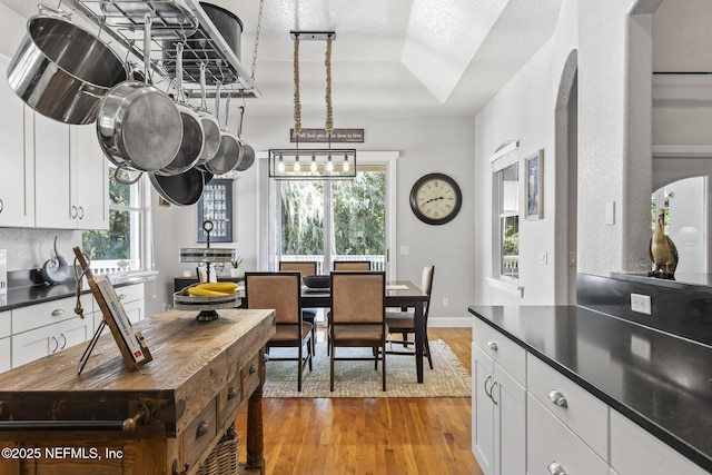 4 Pamela Pkwy, Palm Coast, FL 32137 - dining room featuring baseboards, light wood-type flooring, and arched walkways