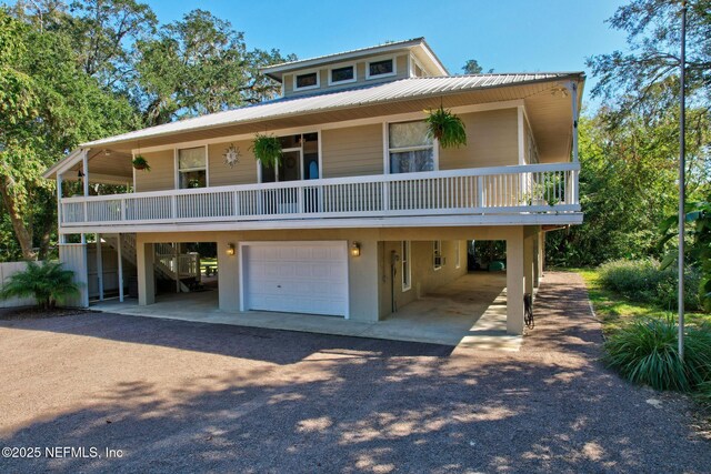 4 Pamela Pkwy, Palm Coast, FL 32137 - view of front of house with driveway, an attached garage, and metal roof
