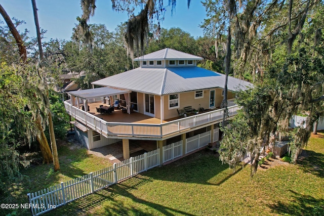 4 Pamela Pkwy, Palm Coast, FL 32137 - back of property featuring metal roof, fence, a wooden deck, and a yard