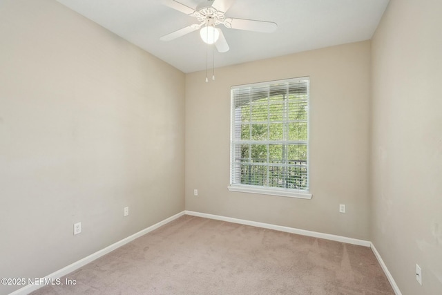 carpeted empty room with baseboards and a ceiling fan