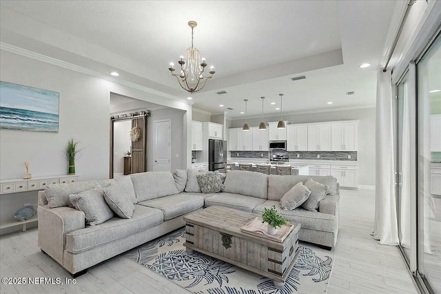 living room featuring crown molding, recessed lighting, an inviting chandelier, and light wood-type flooring