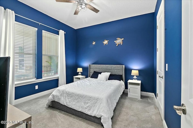 carpeted bedroom featuring a ceiling fan and baseboards