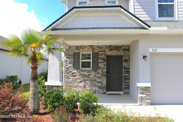 view of exterior entry featuring stone siding, a garage, and stucco siding