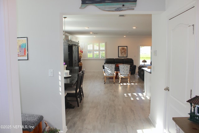 hallway with baseboards, visible vents, light wood-style flooring, and recessed lighting