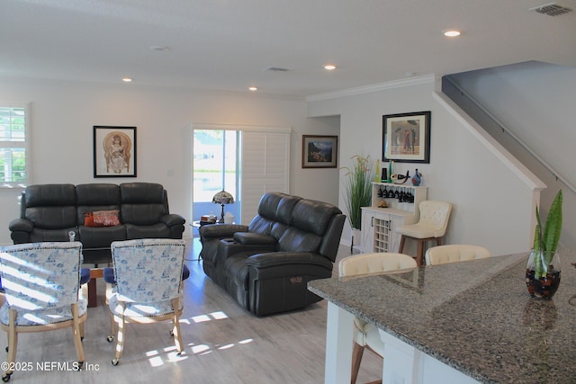 living area with light wood finished floors, visible vents, ornamental molding, and recessed lighting