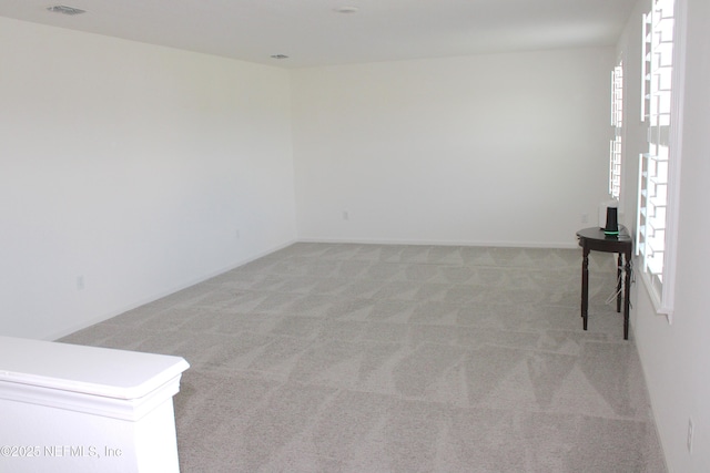 spare room featuring light carpet