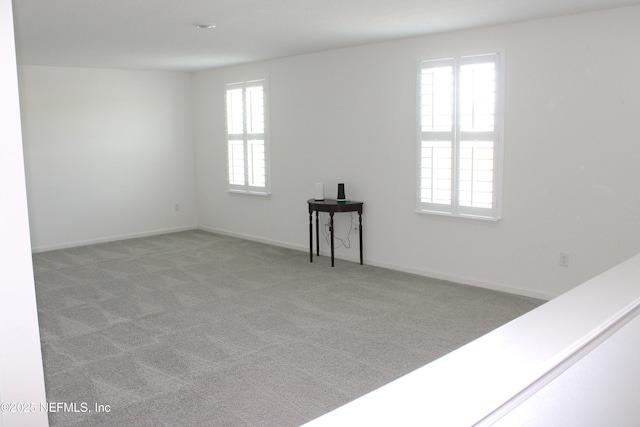empty room with light carpet and baseboards