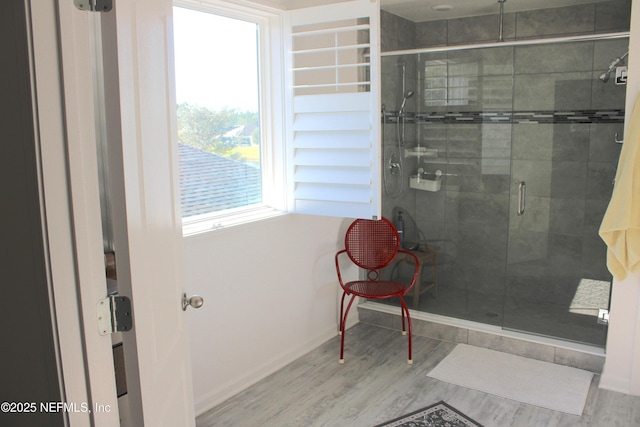bathroom with a shower stall, baseboards, and wood finished floors