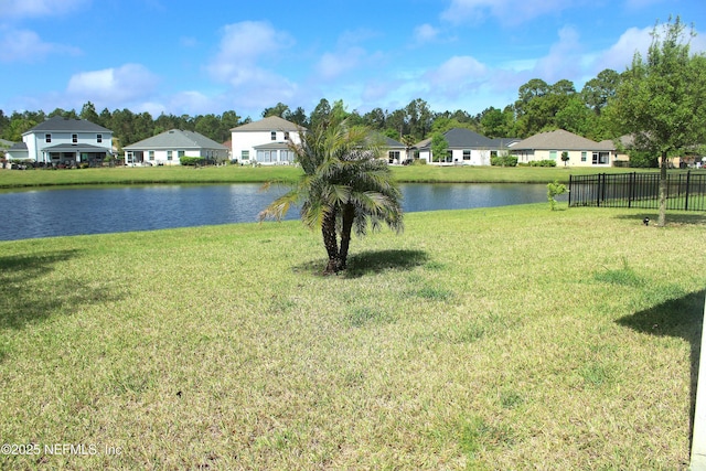 view of water feature with a residential view and fence