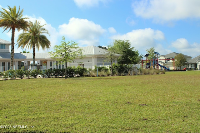 view of yard featuring playground community and fence