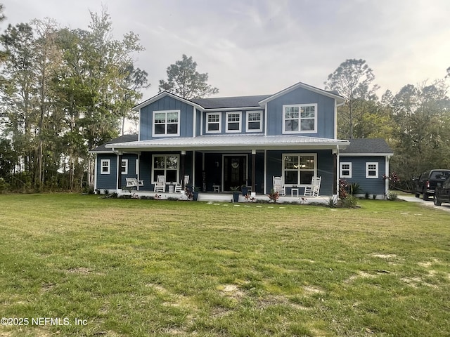 104 W Grandview Dr, East Palatka, FL 32131 - view of front of home with board and batten siding, covered porch, and a front lawn