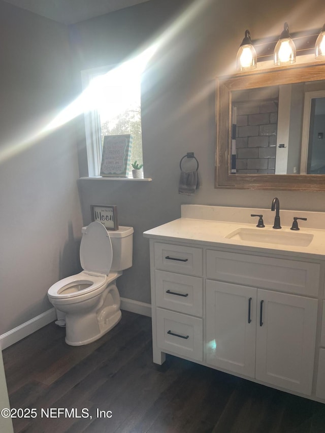 104 W Grandview Dr, East Palatka, FL 32131 - bathroom with vanity, baseboards, toilet, and wood finished floors