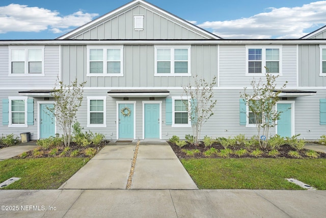 multi unit property with a front yard and board and batten siding