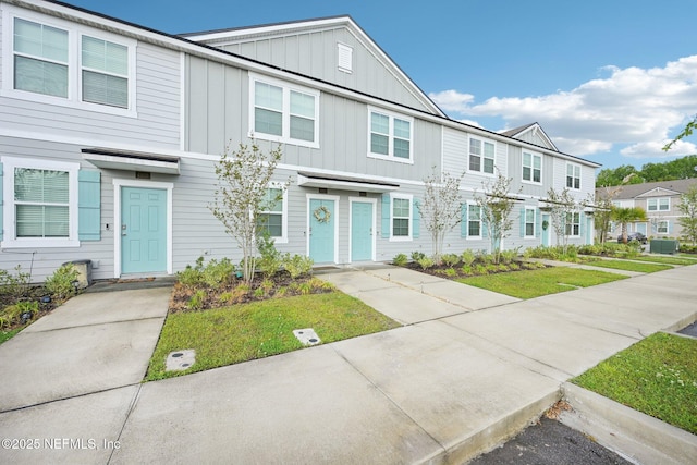 view of property with board and batten siding, a residential view, and a front lawn