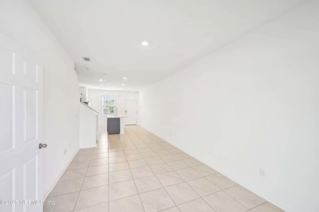 spare room with visible vents, stairs, recessed lighting, a sink, and light tile patterned floors