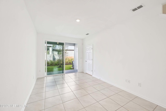 empty room featuring light tile patterned flooring, baseboards, and visible vents