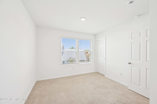 unfurnished bedroom featuring light carpet and baseboards