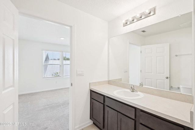 bathroom featuring baseboards, toilet, and vanity